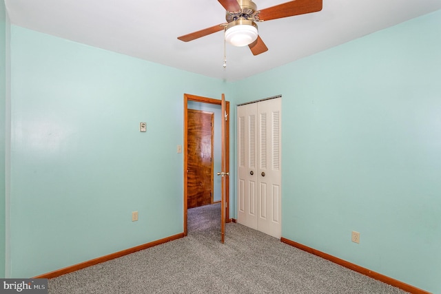 unfurnished bedroom featuring carpet floors, baseboards, and a closet