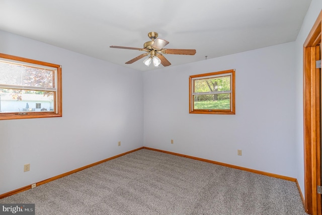 spare room featuring carpet floors, baseboards, and ceiling fan