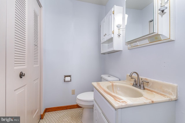 bathroom with toilet, baseboards, tile patterned flooring, and vanity