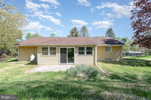 rear view of house featuring a lawn and a patio