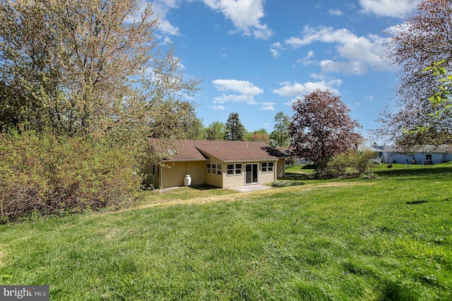 rear view of house featuring a yard