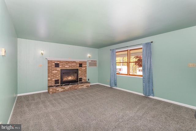 unfurnished living room featuring carpet floors, baseboards, a fireplace, and a wall mounted air conditioner