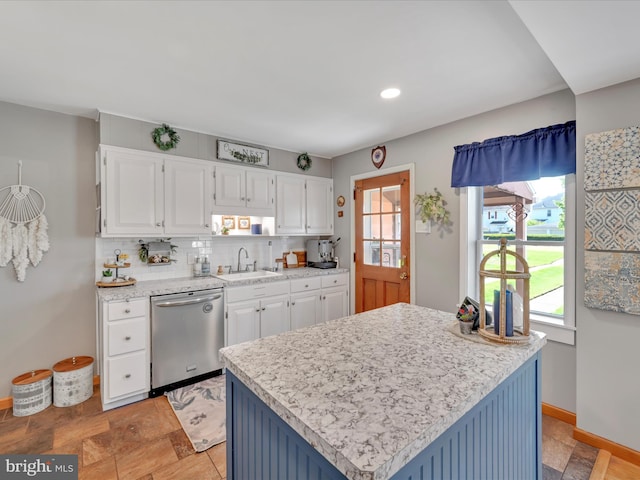 kitchen featuring a sink, decorative backsplash, white cabinets, and dishwasher