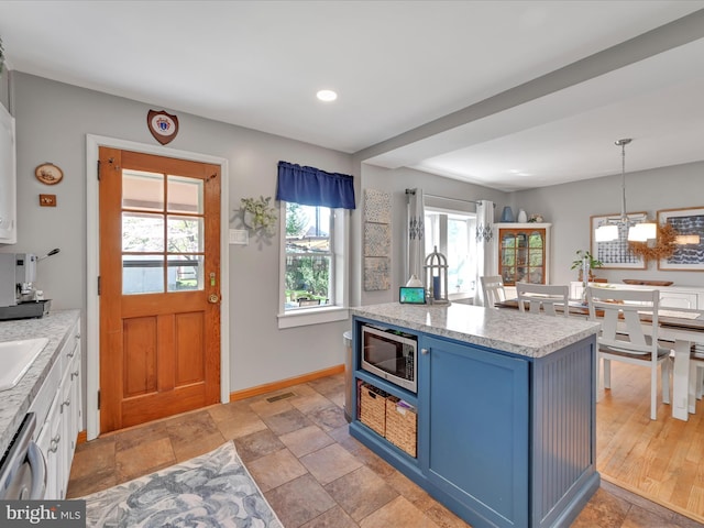 kitchen with visible vents, light countertops, a chandelier, blue cabinets, and appliances with stainless steel finishes