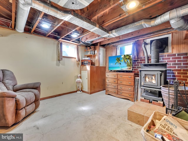 below grade area featuring baseboards and a wood stove