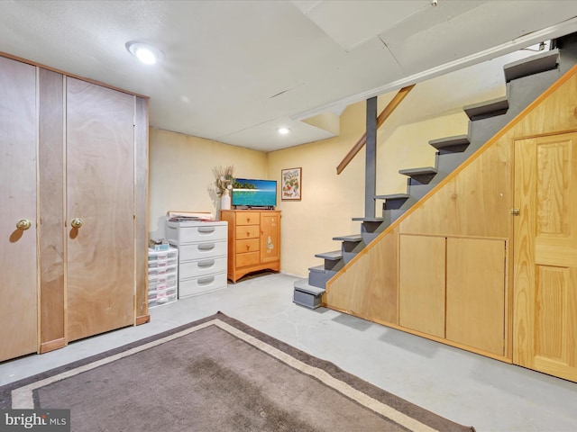 finished basement featuring recessed lighting and stairway
