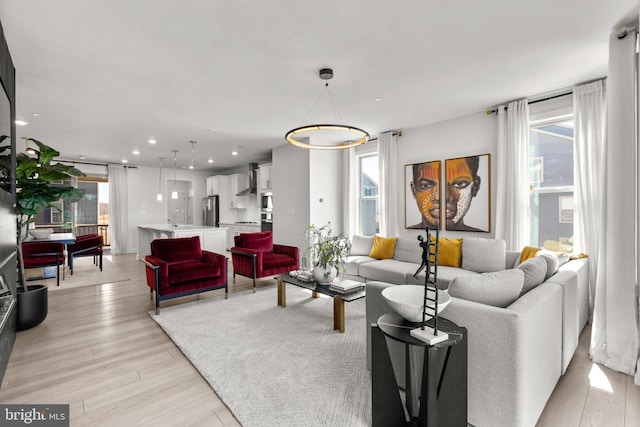 living area with recessed lighting and light wood-style flooring