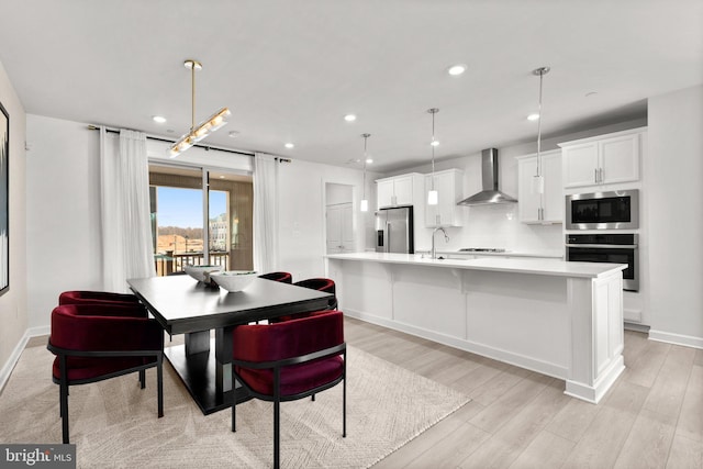 dining space with recessed lighting, baseboards, and light wood-type flooring