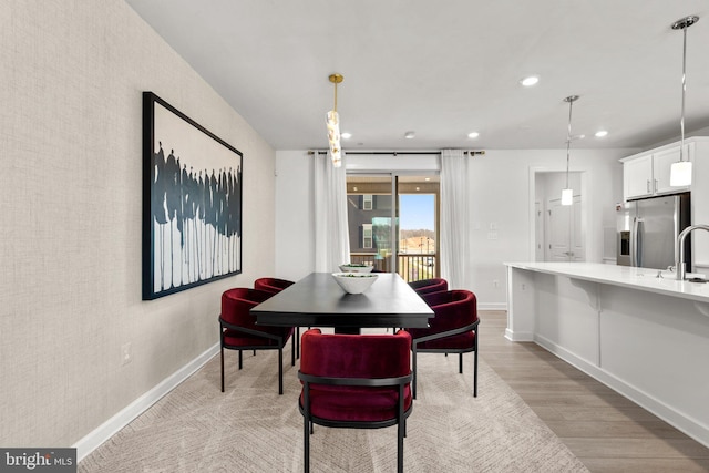 dining area featuring recessed lighting, baseboards, and light wood finished floors