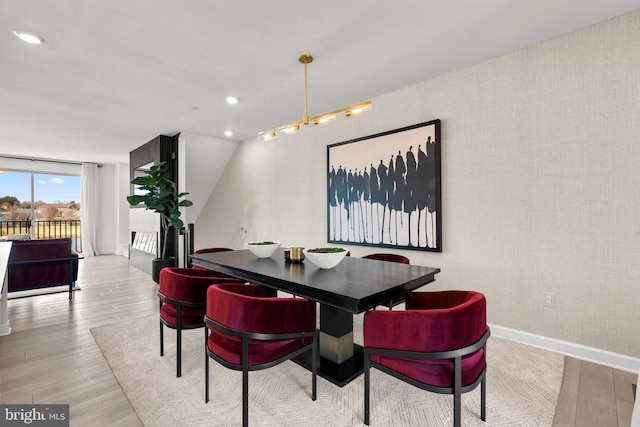 dining space with recessed lighting, baseboards, wallpapered walls, and wood finished floors