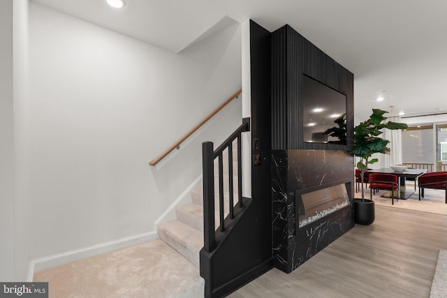 stairs with baseboards, recessed lighting, and wood finished floors