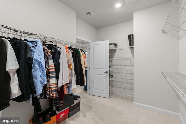 spacious closet with light colored carpet and visible vents