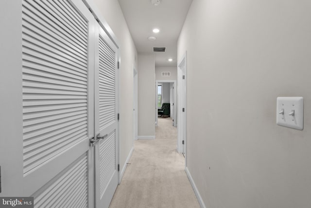 hallway with baseboards, light carpet, recessed lighting, and visible vents