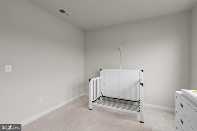 unfurnished bedroom with baseboards, visible vents, and light carpet