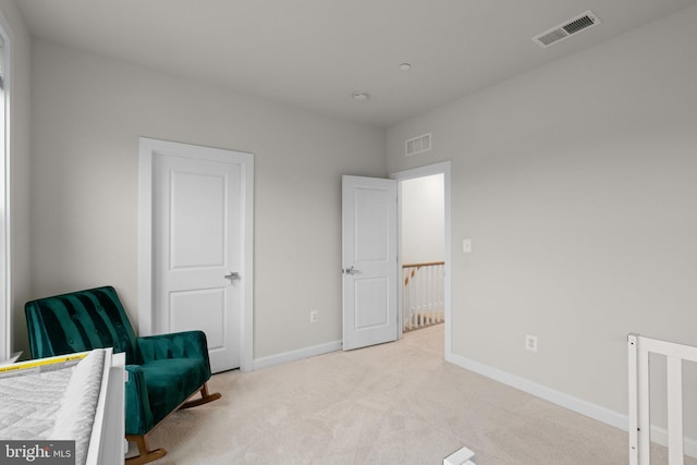 sitting room with baseboards, light carpet, and visible vents
