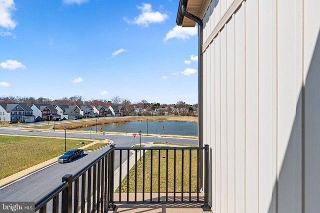 balcony featuring a residential view and a water view