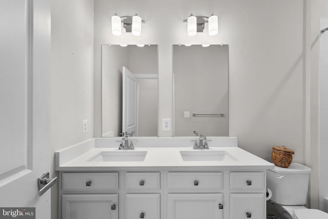 full bathroom with double vanity, a sink, a shower, and toilet