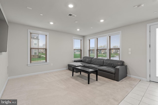 living room with light colored carpet, recessed lighting, baseboards, light tile patterned floors, and visible vents