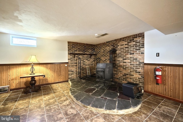 2042 Baltimore Pike, East Berlin, PA 17316 - interior space featuring a wood stove, wood walls, a fire extinguisher, a wainscoted wall, and baseboards