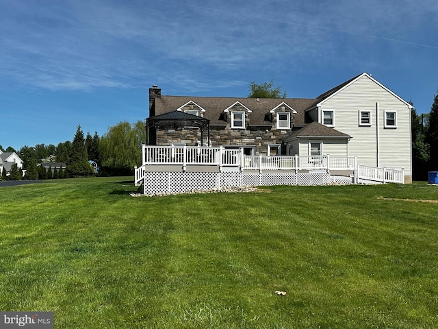 back of house with a gazebo, a chimney, a yard, and a deck