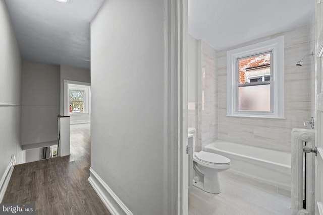 full bath featuring vanity, wood finished floors, toilet, baseboards, and shower / tub combination