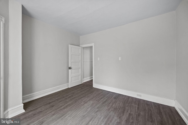 empty room with baseboards and wood finished floors
