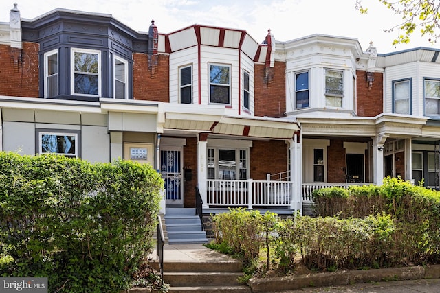 view of front facade with a porch and brick siding