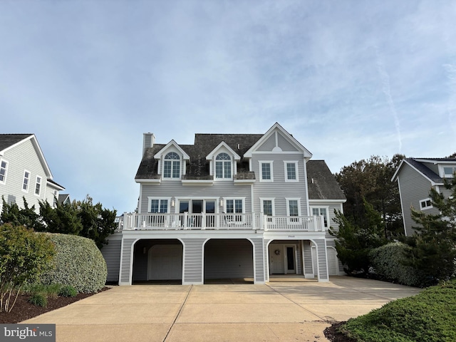 view of front of home with concrete driveway, an attached garage, and a chimney