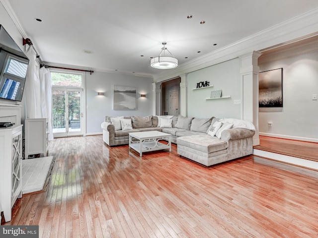 living room featuring light wood finished floors, crown molding, ornate columns, and baseboards