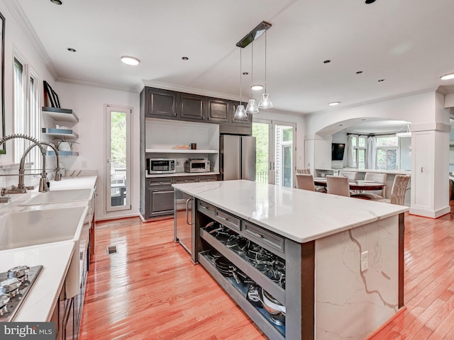 kitchen with open shelves, stainless steel appliances, arched walkways, ornamental molding, and light wood-type flooring