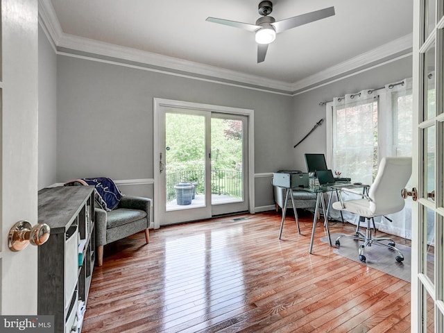 office space featuring wood-type flooring, crown molding, and a ceiling fan