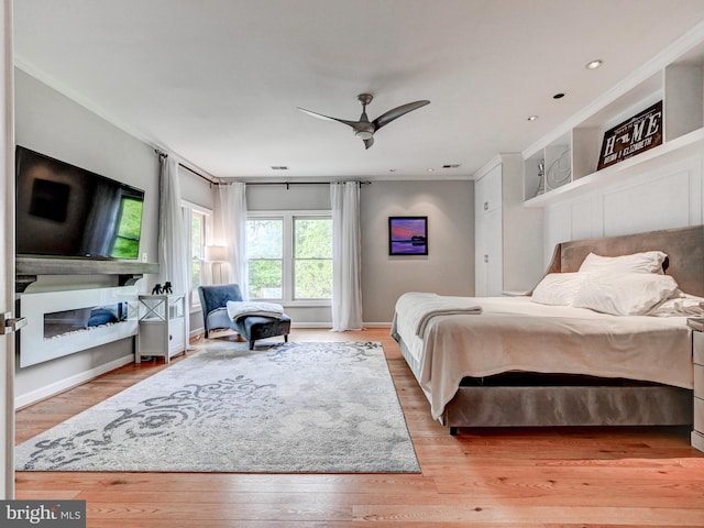bedroom with crown molding, light wood-style flooring, baseboards, a ceiling fan, and recessed lighting