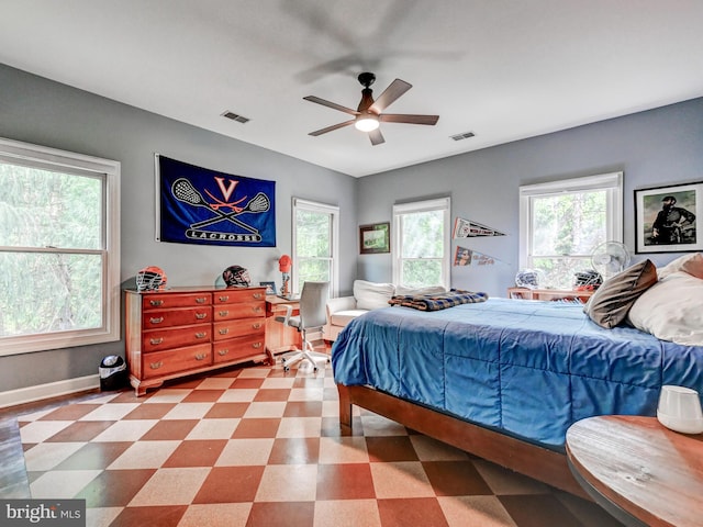 bedroom featuring multiple windows, baseboards, and a ceiling fan