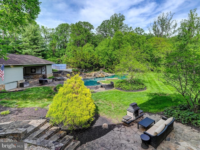 view of grassy yard featuring a patio area, an outdoor pool, and an outdoor fire pit