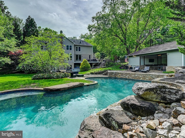 swimming pool with a patio, stairway, a lawn, and a deck