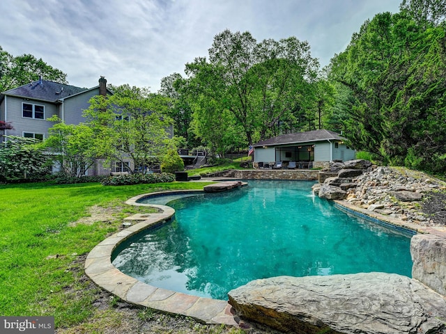 swimming pool with a lawn, an outbuilding, and an exterior structure