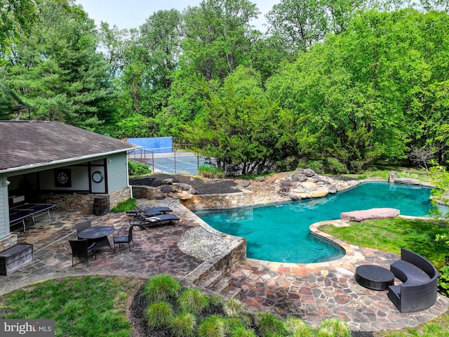 outdoor pool with a patio and fence