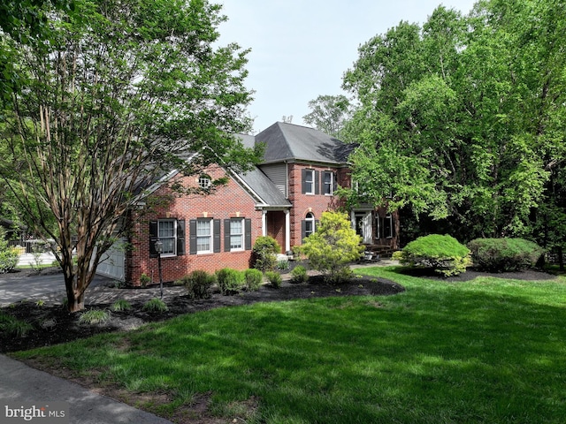 colonial house featuring brick siding and a front lawn