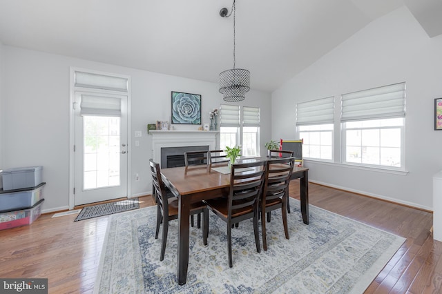 dining space featuring vaulted ceiling, a wealth of natural light, and wood finished floors