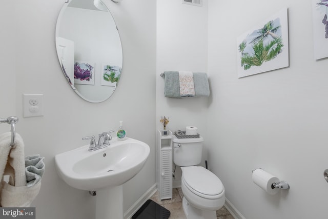bathroom with a sink, baseboards, toilet, and visible vents