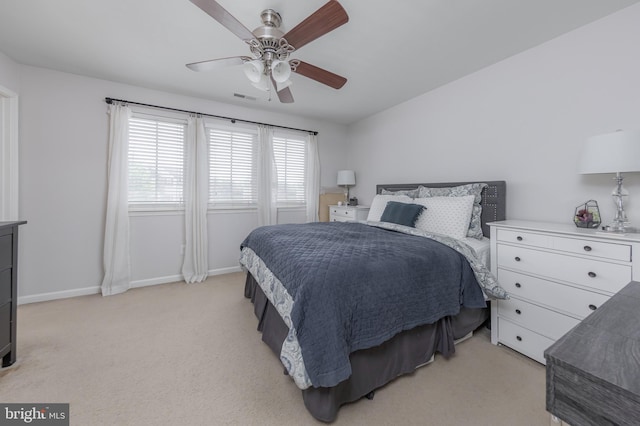 bedroom with baseboards, light carpet, a ceiling fan, and visible vents