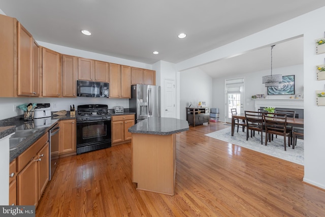kitchen featuring recessed lighting, a center island, black appliances, and light wood finished floors