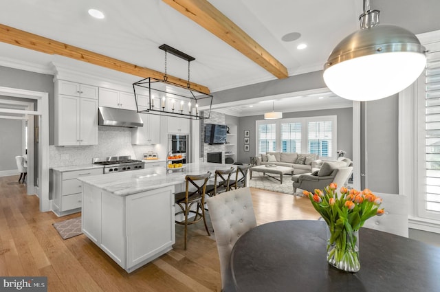 4416 Stanford St, Chevy Chase, MD 20815 - kitchen with beam ceiling, light wood finished floors, tasteful backsplash, under cabinet range hood, and ornamental molding