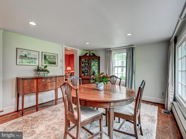 dining area featuring baseboard heating, plenty of natural light, wood finished floors, baseboards, and recessed lighting