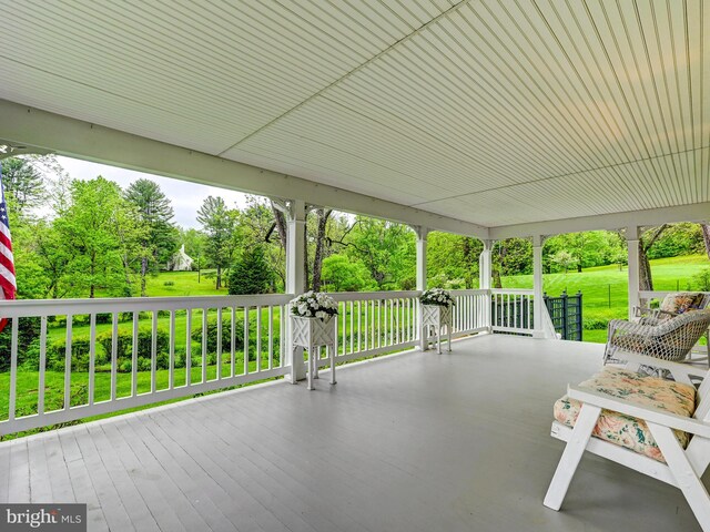 view of patio / terrace featuring view of wooded area and covered porch