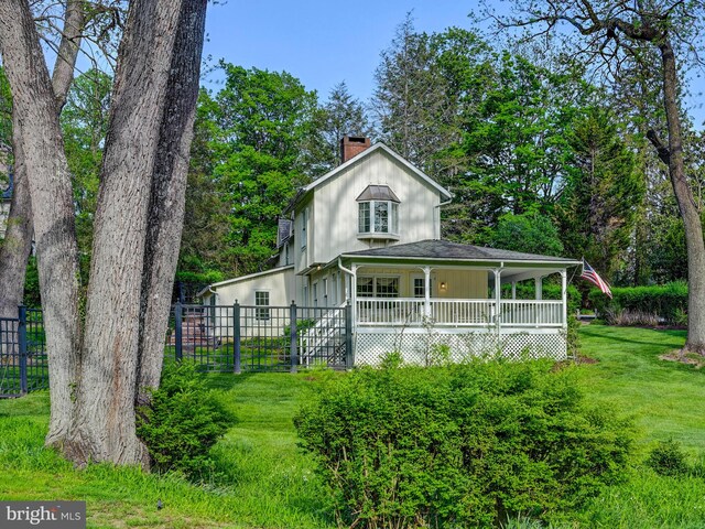 farmhouse inspired home featuring a chimney and covered porch