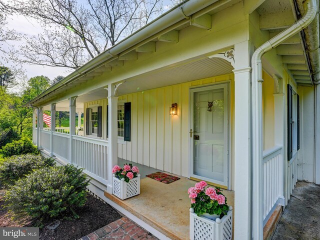 property entrance with board and batten siding and a porch