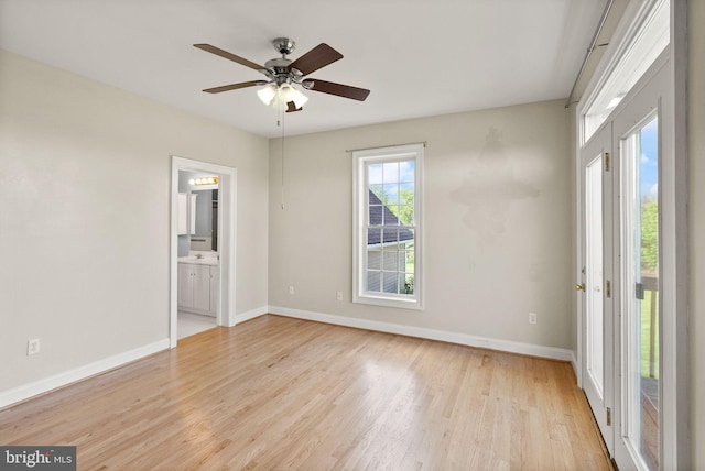 unfurnished bedroom featuring baseboards, connected bathroom, ceiling fan, and light wood-type flooring