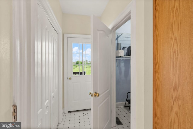 doorway with light floors, baseboards, and visible vents