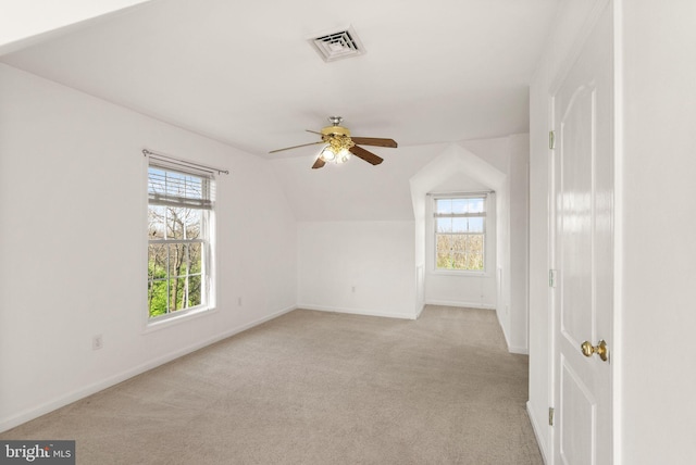 interior space featuring a ceiling fan, visible vents, a wealth of natural light, and lofted ceiling